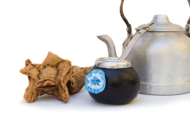 A mate gourd with an Argentine cockade a fried cupcake and a kettle