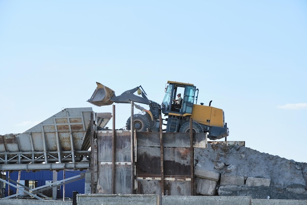 Materiaal laden in breektrechter met behulp van bulldozer in laadcontainer