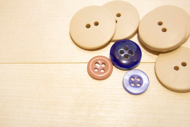 Materials for needlework. Buttons and needles on a wooden table. The concept of hobby, sewing and ne