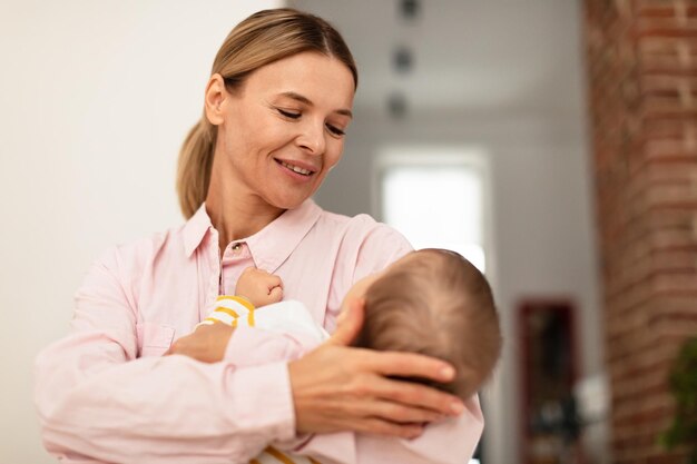 Maternity concept Mother holding her baby daughter on hands conforting her enjoying tender close family moment