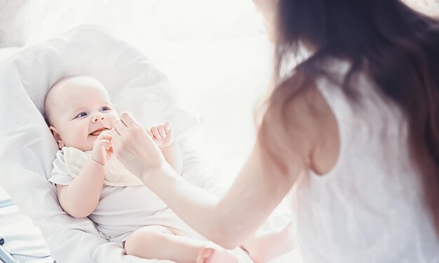 Maternity concept. A young mother feeds her little baby. First lure and breastfeeding. Large family in white clothes.