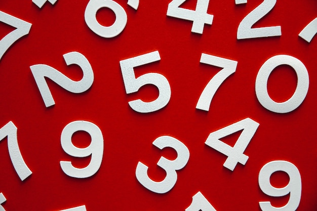 Mathematics background made with solid numbers on a board. Top view, isolated on red