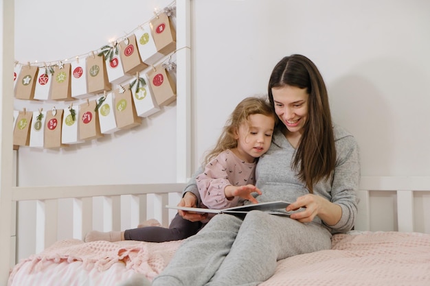 Mather met peuter leest een boek of fotoalbum op kerstavond bij de eco-adventskalender