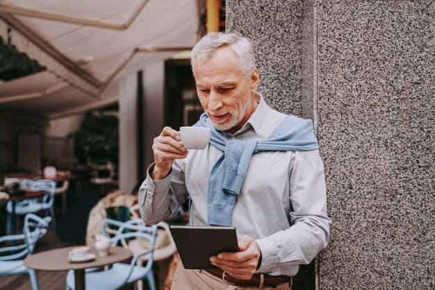 Mature adult using his tablet in a bar coffeehouse