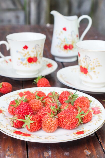 Mature appetizing strawberries scattered on the white plate