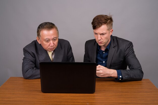 Mature Asian businessman and young Scandinavian businessman agai