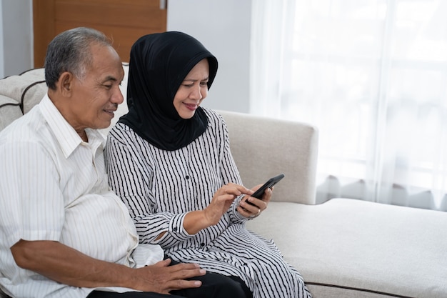 Mature asian couple using smartphone