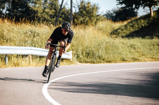 Foto bicicletta di guida dell'atleta maturo su aria fresca