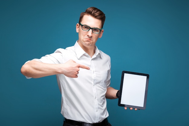 Mature attractive businessman in costly watch, black glasses and white shirt hold empty tablet