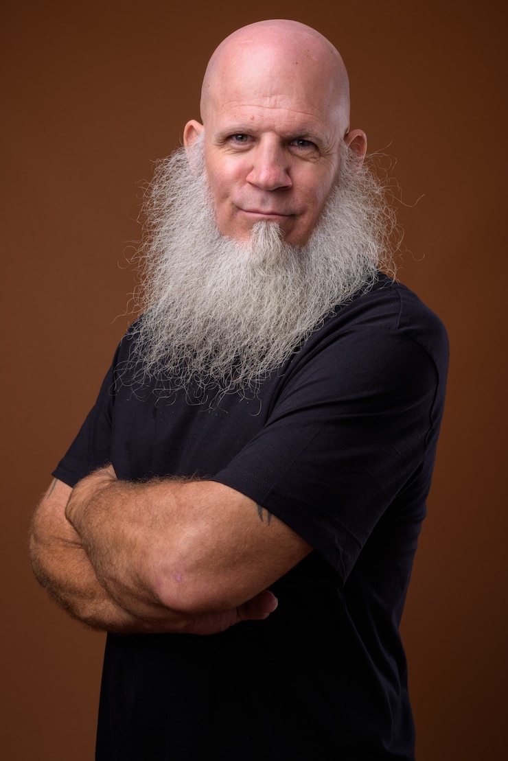 Photo mature bald man with long gray beard on brown