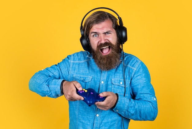 Mature bearded guy has long hair wearing headphones use tv game console technology