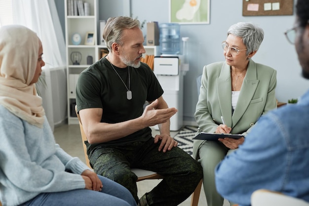 Mature bearded man in casualwear describing his problem to psychologist