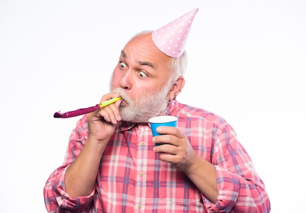 Mature bearded man in pionted hat anniversary holiday celebration man hold party cone hat and whistle happy birthday corporate party happy man with beard retirement party holiday objects