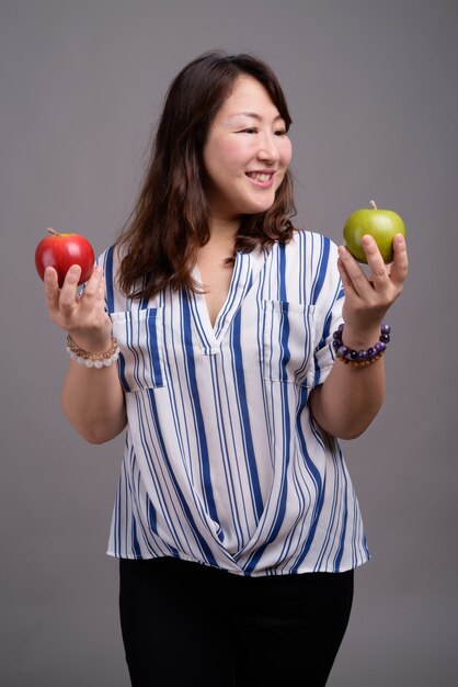 mature beautiful Asian businesswoman holding apples