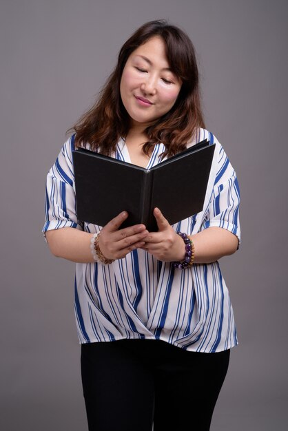 mature beautiful Asian businesswoman holding book