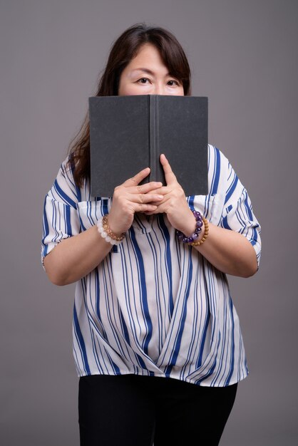 mature beautiful Asian businesswoman holding book