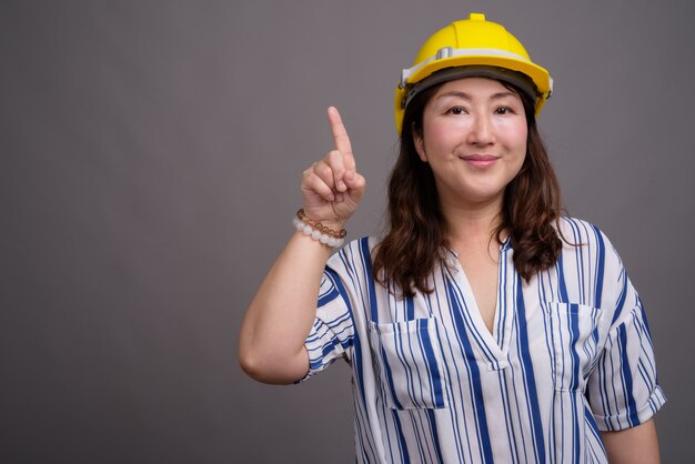 Hardhat 입고 성숙한 아름 다운 아시아 사업가