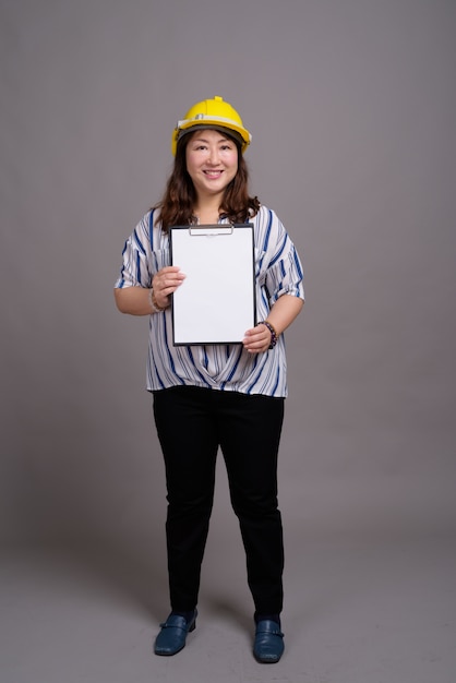 mature beautiful Asian businesswoman wearing hardhat