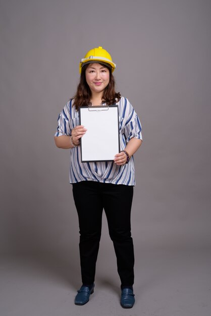 mature beautiful Asian businesswoman wearing hardhat