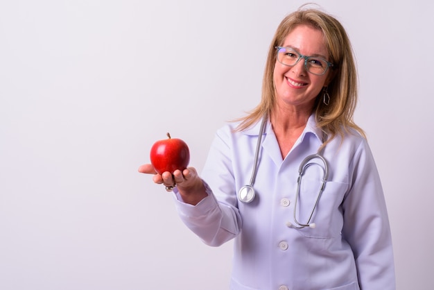 Maturo bella donna bionda medico contro lo spazio bianco