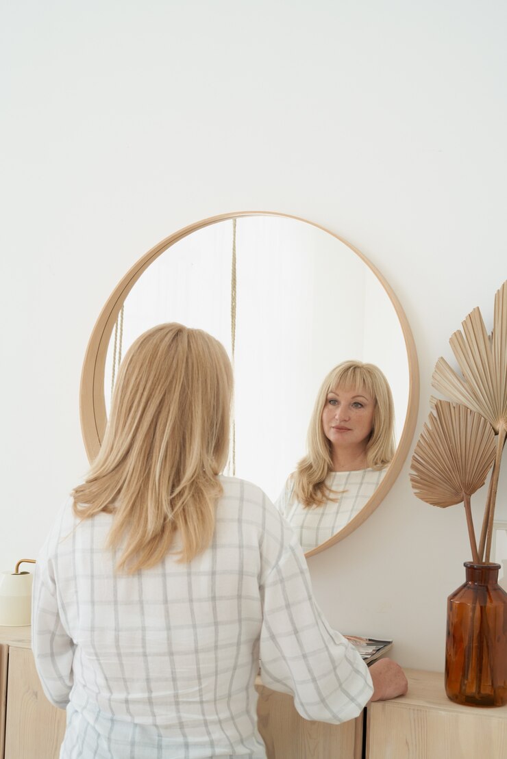 Photo mature beautiful blonde woman with long hair admires reflection standing