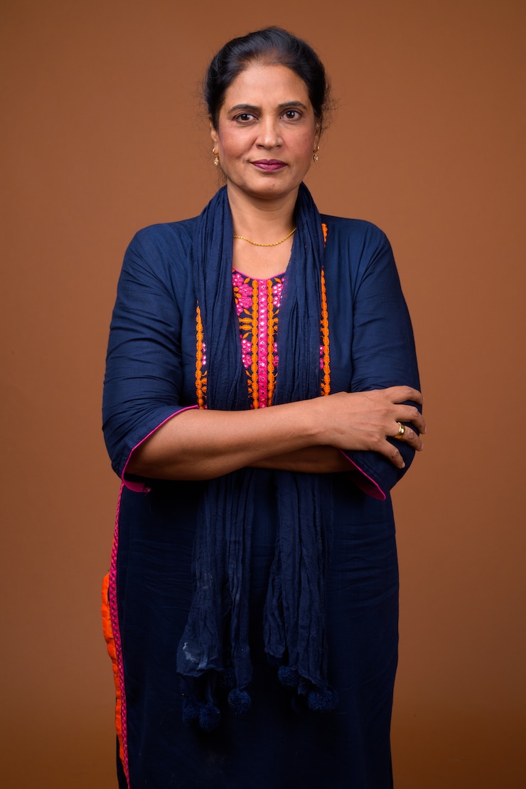 Photo mature beautiful indian woman against brown wall