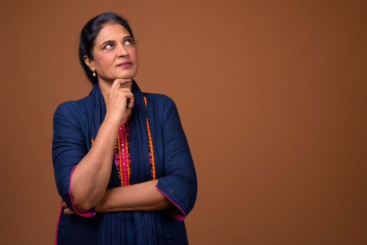 Photo mature beautiful indian woman against brown wall