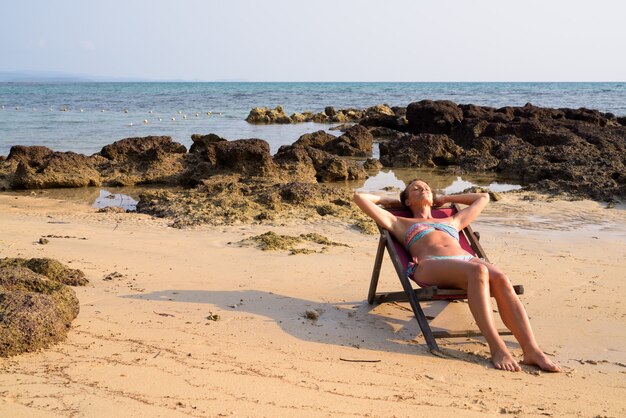 Mature beautiful tourist woman relaxing at the beach