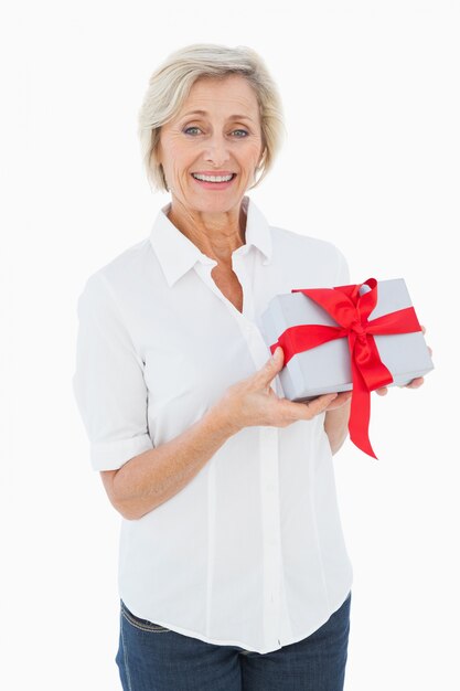 Mature blonde smiling at camera holding gift