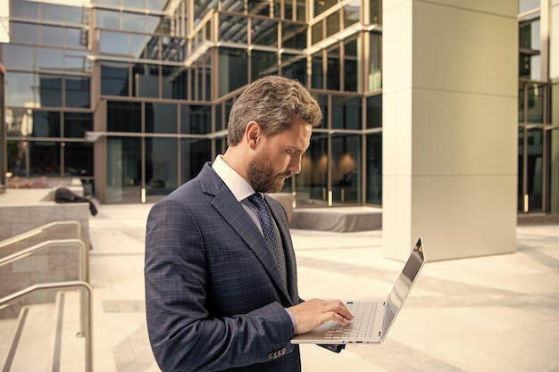 Mature business man in formalwear work on modern laptop outdoor modern life