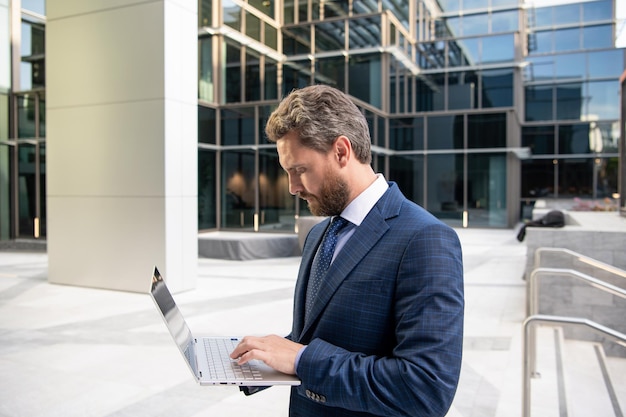 Mature business man in formalwear work on modern laptop outdoor modern life