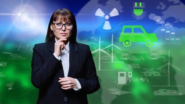 성숙 한 사업가 여성 이 전기 자동차 의 아이콘 과 함께 초록색 배경 에 포즈 를 취 하고 있다
