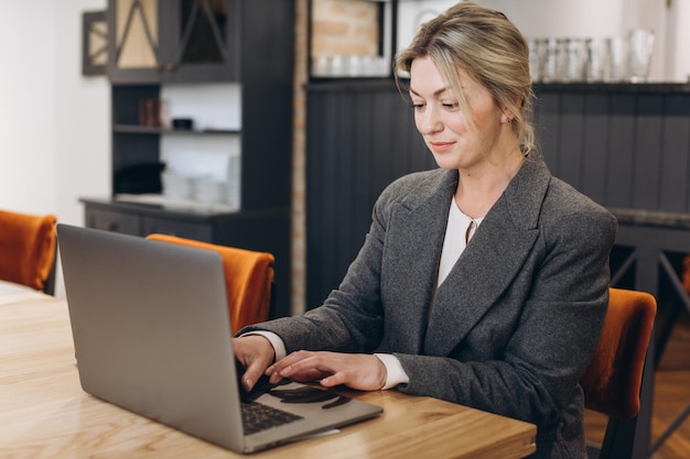 Photo mature business woman restaurant administrator sitting and working on laptop