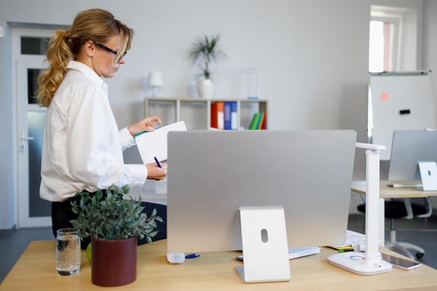 Mature business woman with notepad in the office