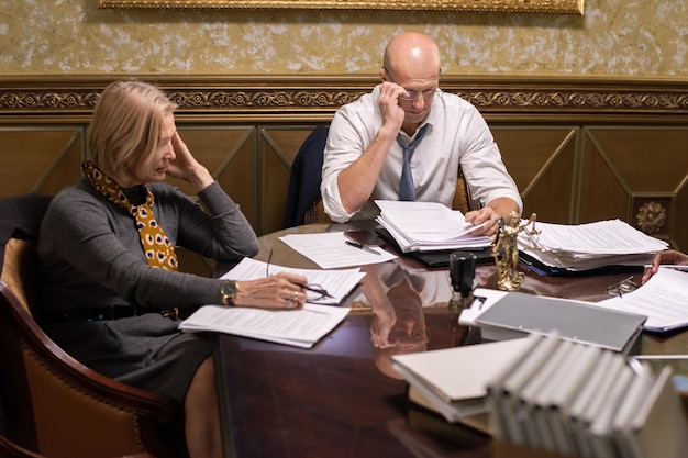 Mature businessman and businesswoman working with papers