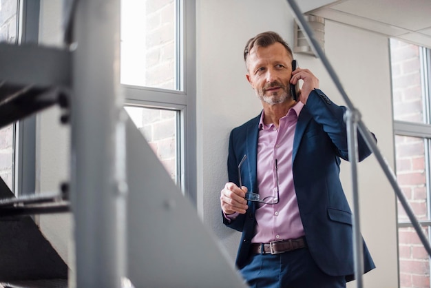 Mature businessman on cell phone at the window