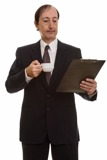 mature businessman holding coffee cup while reading