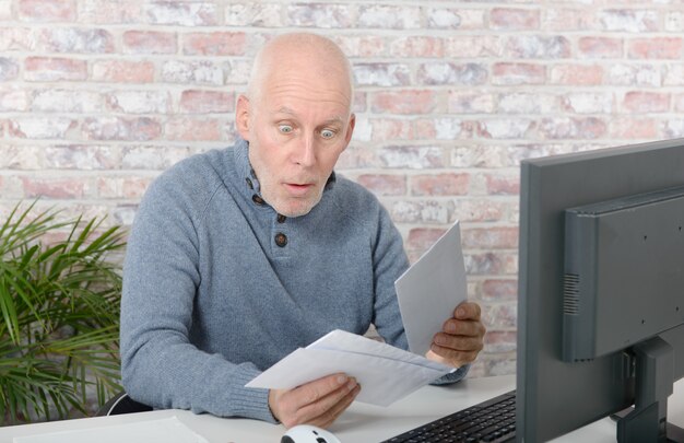 Mature businessman opening letter envelope