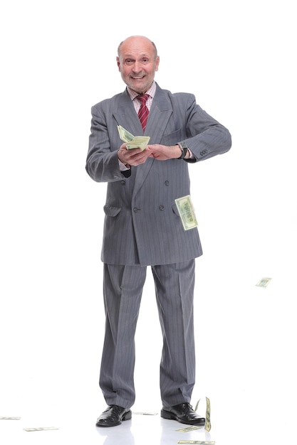 Зрелый бизнесмен в костюме и формальной одежде бросает банкноты в воздушные доллары