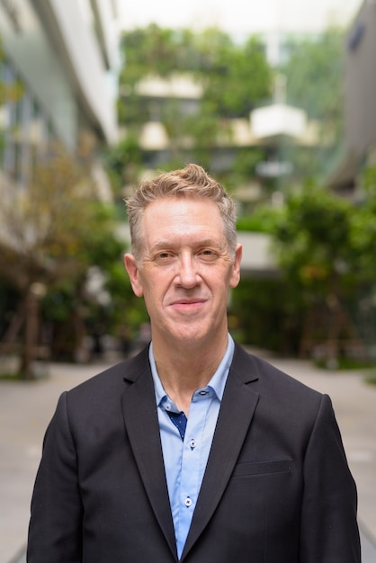 Mature businessman in suit with nature in the city