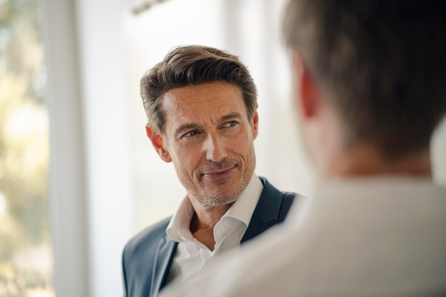 Mature businessman talking to colleague at a meeting