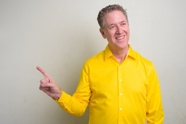 mature businessman wearing yellow shirt on white