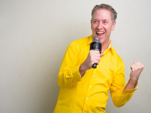 mature businessman wearing yellow shirt on white