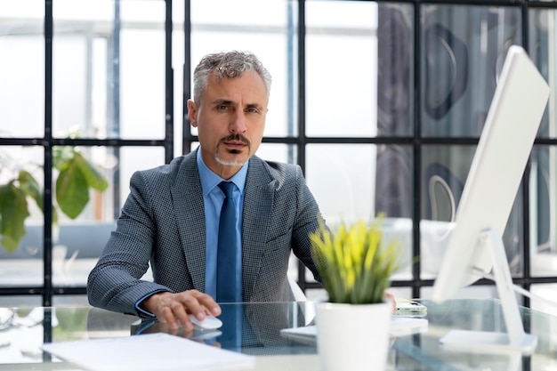 Photo mature businessman working on computer in modern office