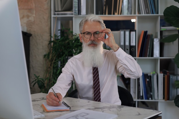 Mature businessman working on computer in modern office.