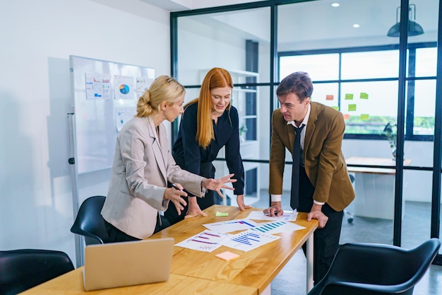 Mature businesswoman talking to young businesswoman at desk in office