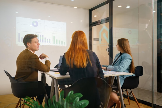 Mature businesswoman talking to young businesswoman at desk in office