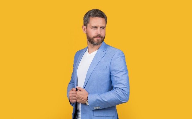 mature caucasian boss in jacket isolated on yellow background boss in studio