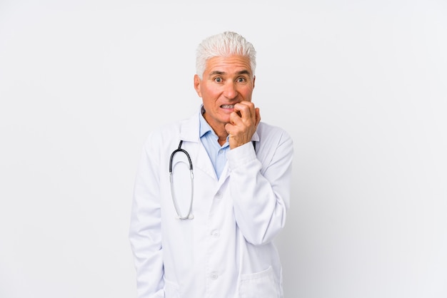 Mature caucasian doctor man biting fingernails, nervous and very anxious.