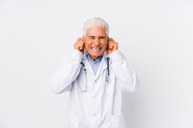 Mature caucasian doctor man covering ears with hands.